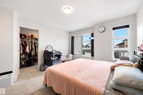 Bedroom with light-toned walls, textured carpet flooring, and a flush-mount ceiling light - 3193 Checknita Way, Edmonton, AB - Indoor Photo Showing Bedroom