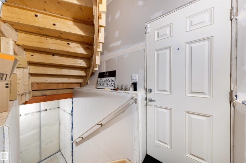 Wood staircase with open risers and a multi-panel white entry door - 3193 Checknita Way, Edmonton, AB - Indoor Photo Showing Other Room