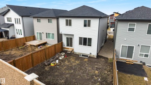 Spacious backyard featuring a wooden privacy fence, a wooden deck, and a gravel side path - 3193 Checknita Way, Edmonton, AB - Outdoor With Exterior