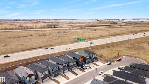 Aerial perspective showcasing a residential development with contemporary homes featuring varied exterior finishes, attached garages, and paved driveways - 3193 Checknita Way, Edmonton, AB - Outdoor With View