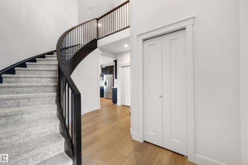 Curved staircase with dark wood-finish handrail and light-toned carpeting - 3193 Checknita Way, Edmonton, AB - Indoor Photo Showing Other Room