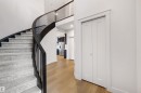 Curved staircase with dark wood-finish handrail and light-toned carpeting - 3193 Checknita Way, Edmonton, AB  - Indoor Photo Showing Other Room 