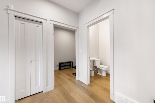 White interior doors with contemporary trim, light wood-finish flooring throughout, and a compact half-bath - 3193 Checknita Way, Edmonton, AB - Indoor