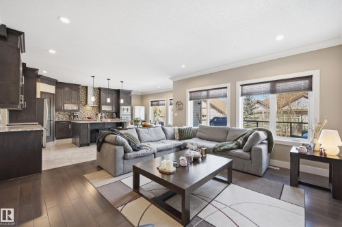 The open-concept living area features hardwood floors, recessed lighting, and large windows that provide abundant natural light - 2018 Armitage Green, Edmonton, AB - Indoor Photo Showing Living Room