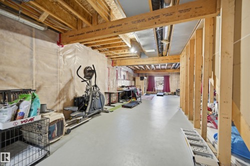 The property features an unfinished basement with exposed wooden beams and structural framing, offering significant potential for customization - 2018 Armitage Green, Edmonton, AB - Indoor Photo Showing Other Room