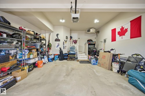 The property includes a spacious garage with a concrete floor, overhead lighting, and an automatic garage door opener - 2018 Armitage Green, Edmonton, AB - Indoor Photo Showing Garage