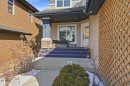 The property features a front porch with blue steps, a white entry door with decorative glass, and a stone-clad column - 2018 Armitage Green, Edmonton, AB  - Outdoor 