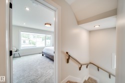 Open doorway revealing an interior room with large horizontal windows, recessed lighting, and light-toned carpeting - 