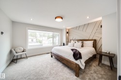 Bedroom featuring a decorative accent wall, light-toned carpet, recessed lighting, and a large window - 