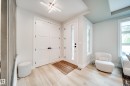 Bright entryway featuring light wood-finish flooring and a contemporary linear ceiling light fixture - 9625 101 Street, Edmonton, AB  - Indoor Photo Showing Other Room 