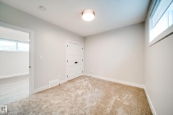 Carpeted room featuring a flush-mount ceiling light, white trim, and a horizontal window - 