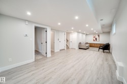 Spacious finished area featuring light wood-finish flooring, recessed lighting, and white trim - 