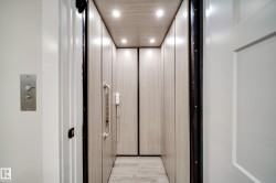 Private interior elevator featuring recessed lighting, wood-finish wall panels, and coordinating wood-finish flooring - 