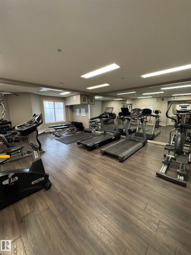 Fitness center featuring wood-finish flooring, recessed lighting, and mirrored walls - 307 6084 Stanton Drive, Edmonton, AB - Indoor Photo Showing Gym Room