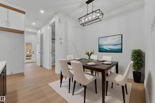 Open-concept dining area featuring light wood-finish flooring, recessed lighting, and a modern rectangular chandelier - 456 Crystal Creek Link, Leduc, AB - Indoor Photo Showing Dining Room