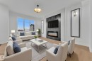 Living area featuring light wood-finish flooring and white walls - 456 Crystal Creek Link, Leduc, AB  - Indoor Photo Showing Living Room With Fireplace 