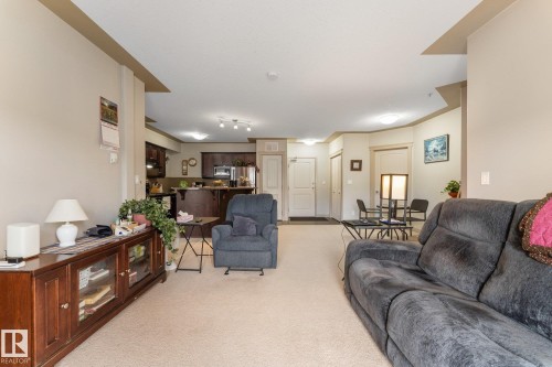 Spacious living area with carpet flooring and light-colored walls - #211 4415 48 St, Leduc, AB - Indoor Photo Showing Living Room