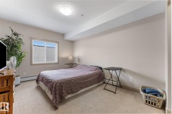 The room features a window with blinds, carpeted flooring, and neutral-colored walls - 