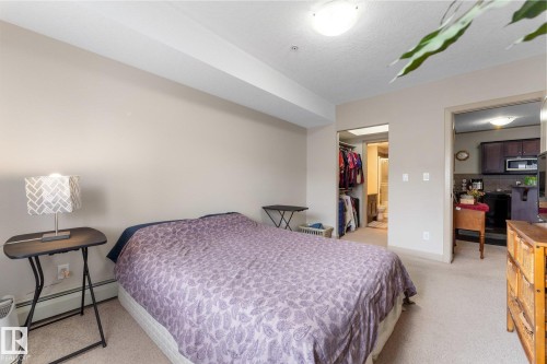 Well-maintained bedroom featuring neutral-toned walls and carpeting, with a ceiling-mounted light fixture - #211 4415 48 St, Leduc, AB - Indoor Photo Showing Bedroom