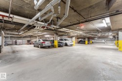 The property includes a spacious underground parking area with concrete flooring, overhead piping, and yellow-painted support columns - 