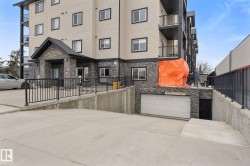 The property features a multi-story exterior with balconies, a stone facade, and a private garage access - 