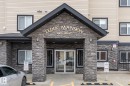The property features a prominent entrance with stacked stone detailing and an overhang - #211 4415 48 St, Leduc, AB  - Outdoor 