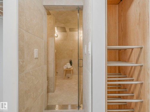 The bathroom features an expansive tiled shower with a clear glass enclosure and a separate custom wooden shelving unit - 807 10134 100 Street, Edmonton, AB - Indoor Photo Showing Bathroom