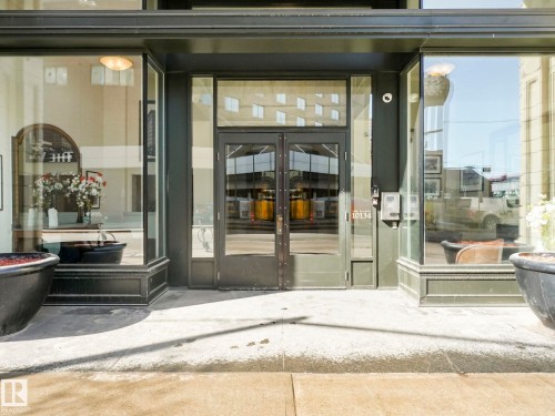 The property features a storefront entrance with large display windows, double entry doors, and a modern intercom system - 807 10134 100 Street, Edmonton, AB - Outdoor