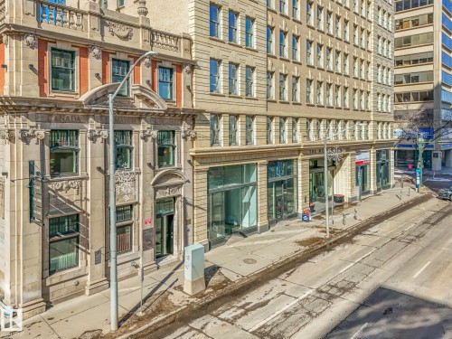 The property features a stone facade with intricate architectural details and multiple windows, providing a classic aesthetic - 807 10134 100 Street, Edmonton, AB - Outdoor