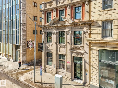 The property features a stone facade with intricate architectural details and tall windows - 807 10134 100 Street, Edmonton, AB - Outdoor With Facade