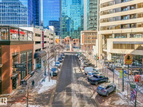 Downtown street view featuring a brick building with a restaurant, street parking, and a backdrop of modern high-rise buildings - 807 10134 100 Street, Edmonton, AB -  Photo Showing Other Room