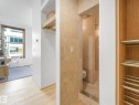 The property features hardwood floors, a tiled shower with a toilet, and built-in shelving with hanging space - 807 10134 100 Street, Edmonton, AB  - Indoor 