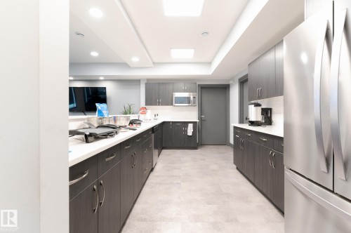 Social Area  Fireplace  Pool Table  Dart Boards and Coffee Station  Exercise Room  Banquet Room  Spacious Kitchenette  Flex Space For Meetings, Crafts, Card Tournaments - #207 50 Heatherglen Dr, Spruce Grove, AB - Indoor Photo Showing Kitchen With Double Sink