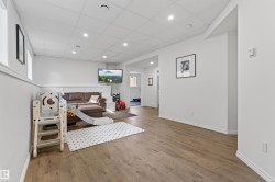 Spacious finished lower level featuring recessed lighting, wood-finish flooring, and white baseboards - 