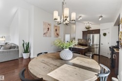 Open-concept dining area featuring wood-finish flooring, a contemporary chandelier, and recessed lighting - 