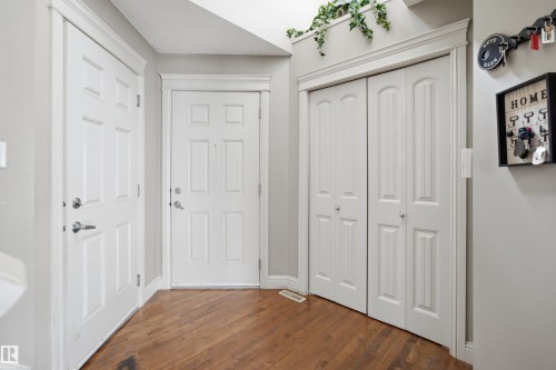 Entryway featuring wood-finish flooring, white paneled doors, bi-fold closet doors, and light gray wall paint - 3533 11 Street, Edmonton, AB - Indoor Photo Showing Other Room