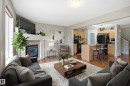 Living area featuring multiple windows with blinds, a prominent ceiling light fixture, wall-mounted artwork, and wall-to-wall carpeting - 3533 11 Street, Edmonton, AB  - Indoor Photo Showing Living Room 