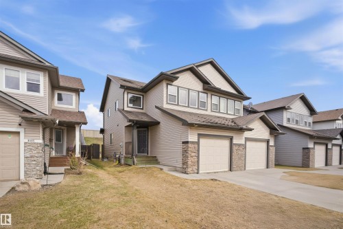 Multi-level residence featuring light-toned siding and a prominent stone accent facade - 3533 11 Street, Edmonton, AB - Outdoor With Facade