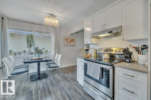 Modern kitchen and dining area featuring wood-finish flooring - 7715 73 Avenue, Edmonton, AB - Indoor Photo Showing Kitchen With Stainless Steel Kitchen