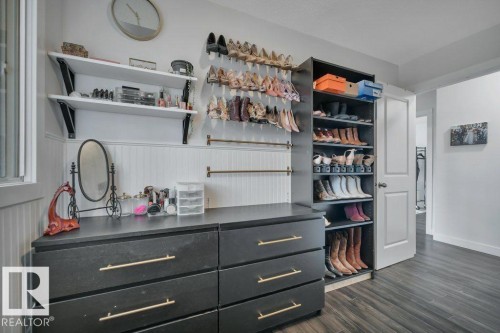 Integrated closet system featuring a black dresser with gold-finish hardware, open shelving, and dedicated shoe storage - 7715 73 Avenue, Edmonton, AB - Indoor