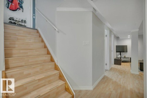 Light wood-finish staircase with white handrail and trim - 7715 73 Avenue, Edmonton, AB - Indoor Photo Showing Other Room