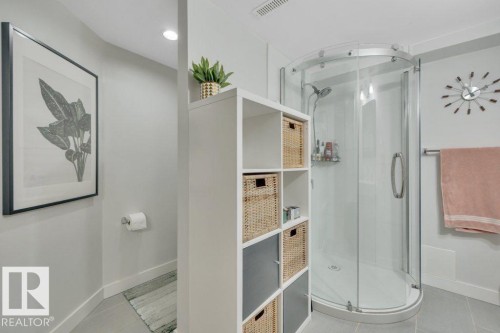 Bathroom featuring a curved glass shower enclosure, recessed lighting, tile flooring, and a built-in modular storage unit - 7715 73 Avenue, Edmonton, AB - Indoor Photo Showing Bathroom