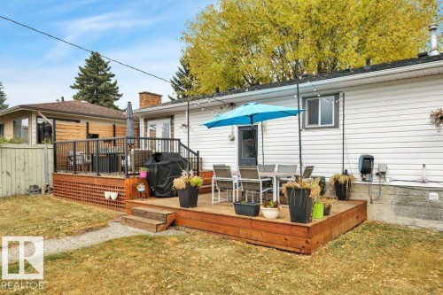 Multi-level wooden deck featuring a lattice skirt, black metal railings, and direct access to the interior - 7715 73 Avenue, Edmonton, AB - Outdoor With Deck Patio Veranda With Exterior