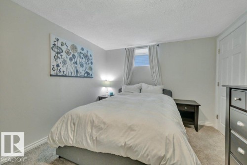 Carpeted room with a window, white baseboards, and a white paneled door - 7715 73 Avenue, Edmonton, AB - Indoor Photo Showing Bedroom