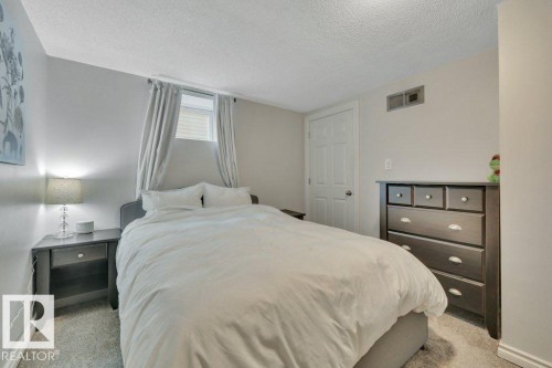 Bedroom featuring light gray walls and textured carpeting - 7715 73 Avenue, Edmonton, AB - Indoor Photo Showing Bedroom