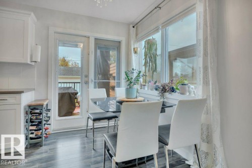 Dining area featuring wood-finish flooring, white cabinetry, and a light-colored countertop - 7715 73 Avenue, Edmonton, AB - Indoor Photo Showing Other Room