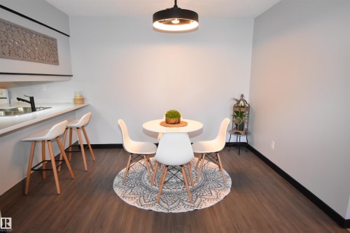 Dining area featuring wood-finish flooring, a contemporary ceiling light fixture, and light-toned walls - 202 24 Alpine Place, St. Albert, AB - Indoor Photo Showing Dining Room