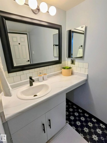 Vanity with built-in cabinetry, an integrated sink, and a matte black faucet - 202 24 Alpine Place, St. Albert, AB - Indoor Photo Showing Bathroom