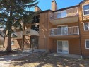 Multi-level building with wood-look siding, featuring multiple balconies with white railings and an arched entrance canopy - 202 24 Alpine Place, St. Albert, AB  - Outdoor With Exterior 