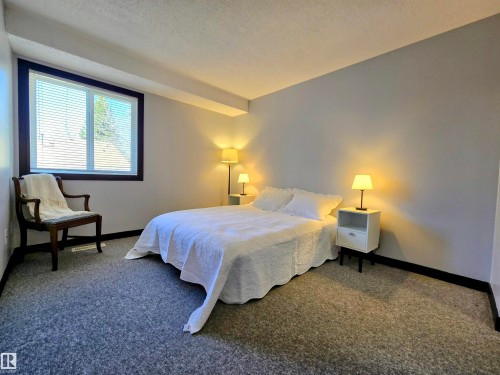 Spacious room featuring neutral grey walls and dark trim - 202 24 Alpine Place, St. Albert, AB - Indoor Photo Showing Bedroom